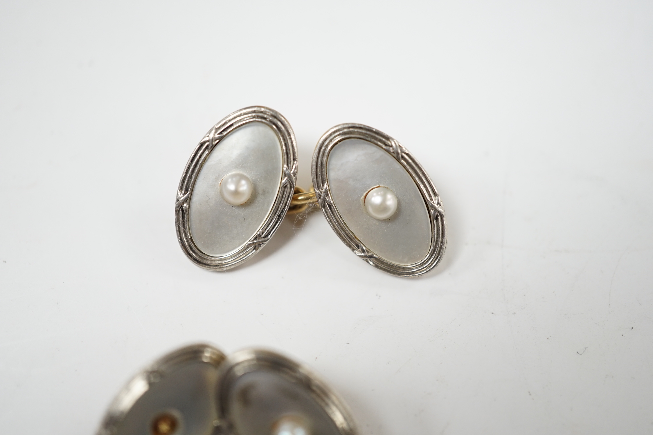 A pair of Edwardian 15ct, mother of pearl and seed pearl set oval cufflinks, 17mm, gross weight 7.3 grams.